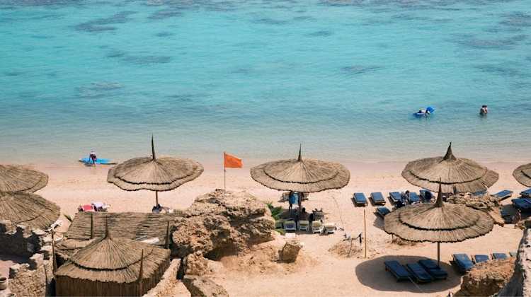 People playing on the beach with umbrellas