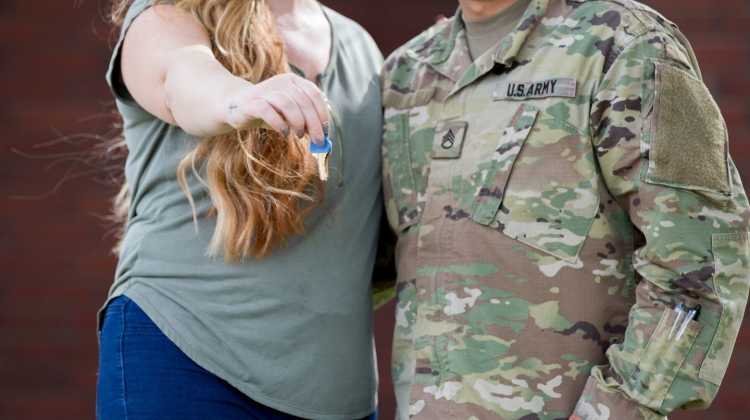 Army couple holding out a key