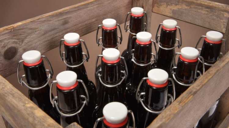a dozen German beer bottles in a wooden packing crate