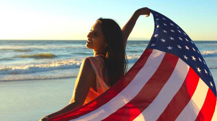 young military spouse on the beach with a flag