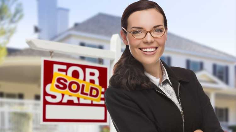 realtor in front of sold sign 
