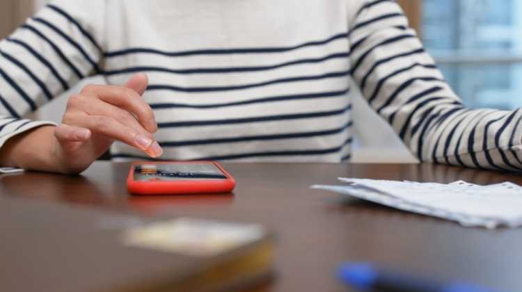 woman with calculator and stack of paperwork