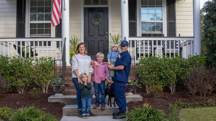 military family standing in front of home