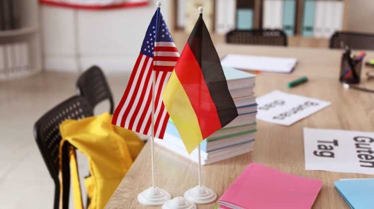 photo of German and American flags on a school desk with school supplies