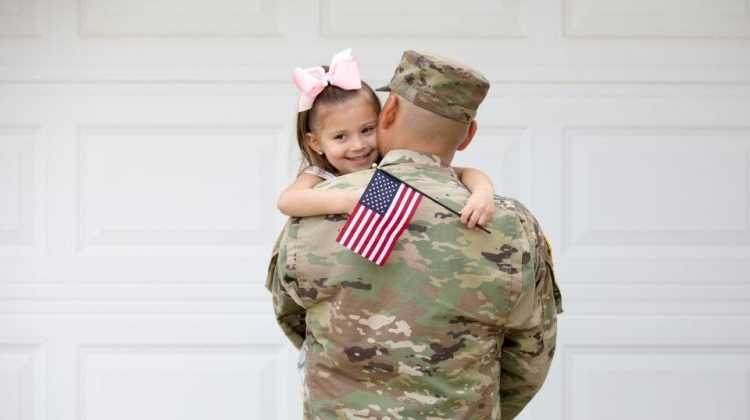 soldier holding child waving flag