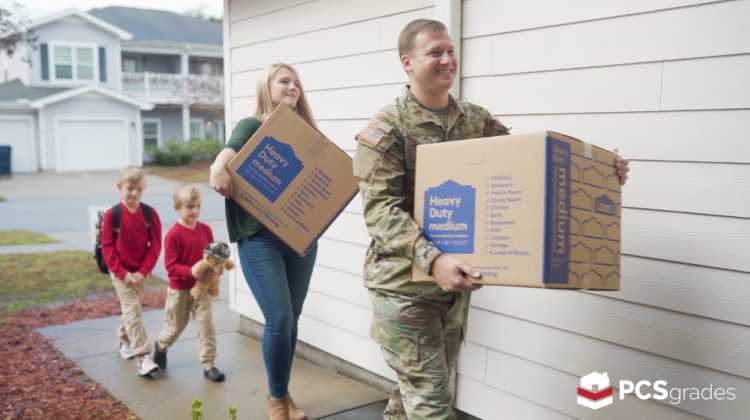 Military family carrying boxes into a home they bought after military retirement