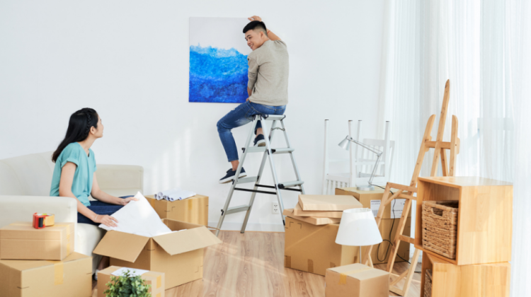 couple moving in and hanging art