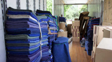 Interior of a moving truck filled with boxes and furniture pads