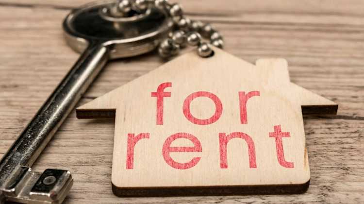 set of house keys with wooden house that says "for rent"