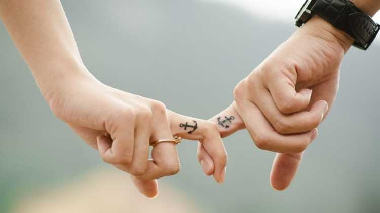 linked fingers with matching anchor tatoo