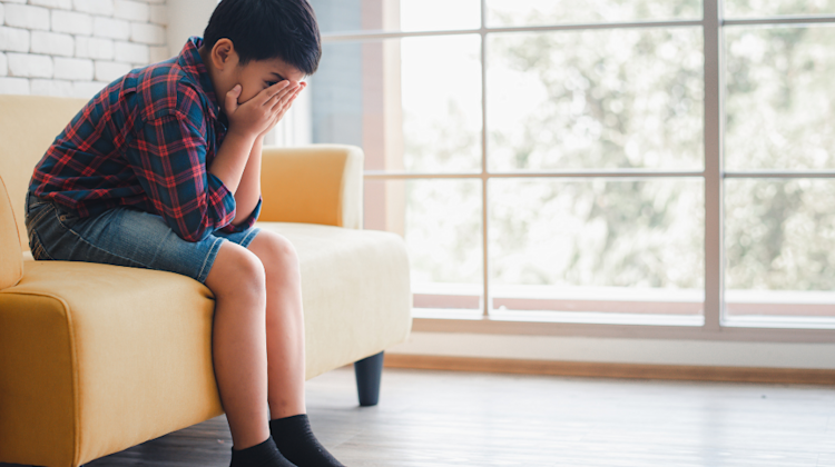Child sitting with head in hands