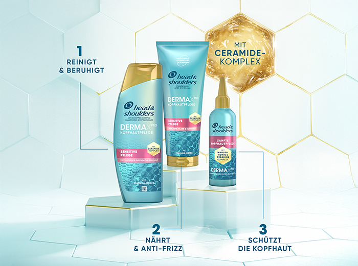 Drei Head & Shoulders DERMA X Pro Sensitive Care Haar- und Kopfhautpflegeprodukte auf weißen geometrischen Podesten vor hellblauem, sechseckigem Hintergrund, mit deutschem Text zu den Produktvorteilen.