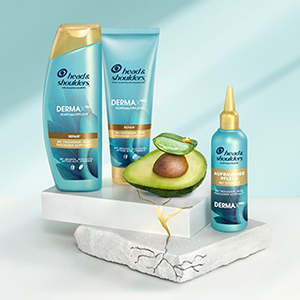 Head & Shoulders Dermaxpro Repair Shampoo, Pflegespülung und Kopfhautmaske neben Avocado- und Aloestückchen.