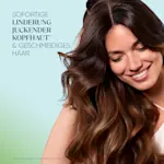 Lächelnde Frau mit langem Haar, Text: „Sofortige Linderung juckender Kopfhaut & geschmeidiges Haar“
