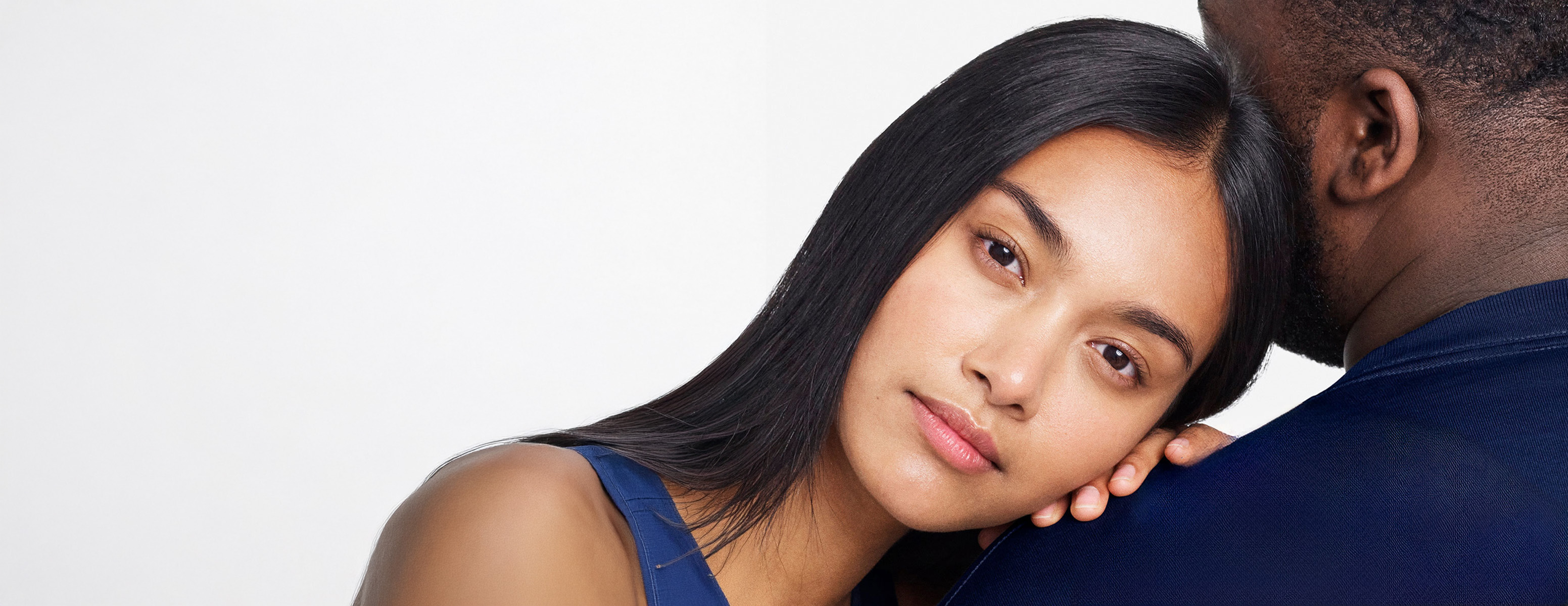 Eine Frau und ein Mann sitzen mit geschlossenen Augen und lehnen sich mit dem Rücken aneinander