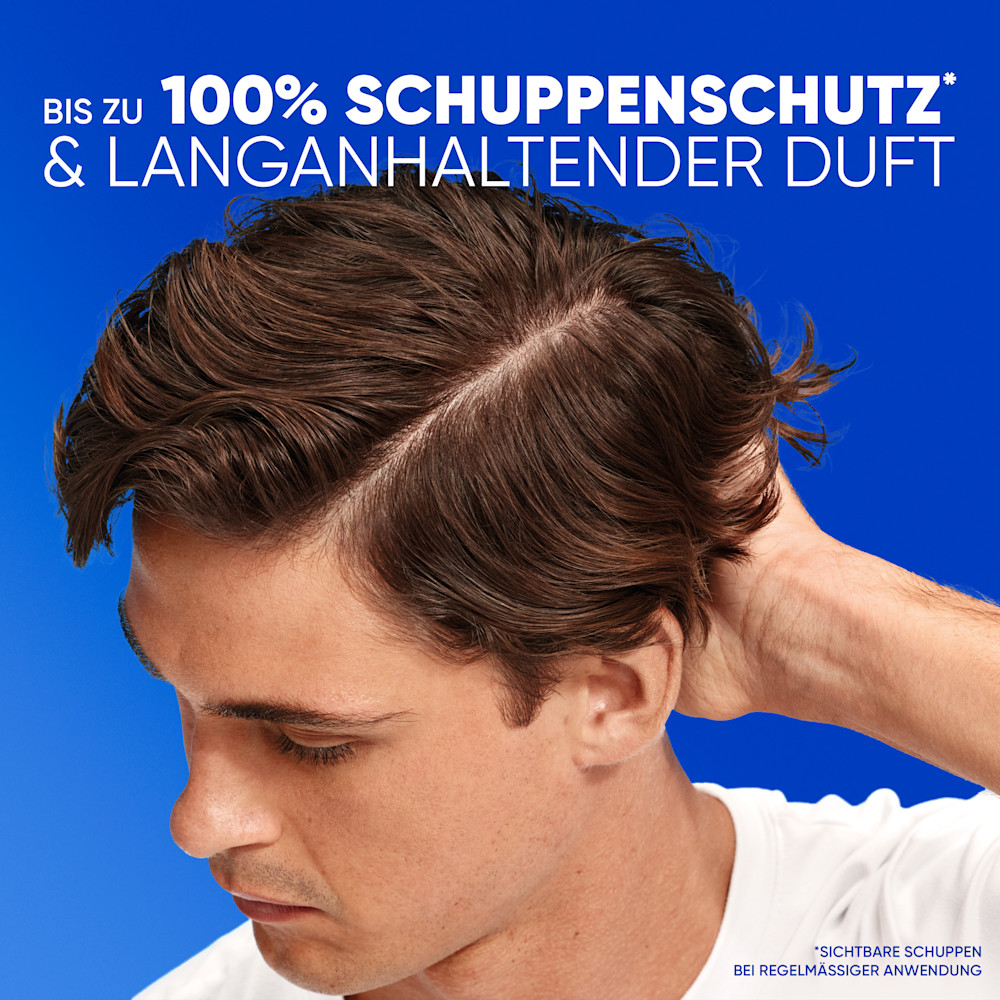 Junger Mann berührt seinen Kopf am Hinterkopf vor blauem Hintergrund, mit Werbetext für 100 % Schuppenschutz und langanhaltenden Duft.