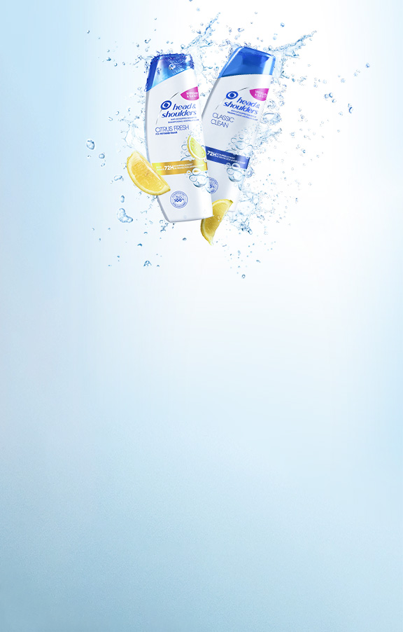 Zwei Shampoo Flaschen auf hellblauem Hintergrund, mit einem Spritzer Wasser