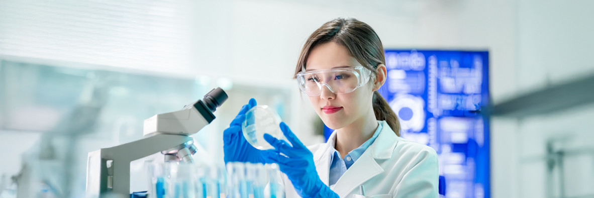 Eine Wissenschaftlerin in blauen Latexhandschuhen arbeitet in einem modernen Labor.