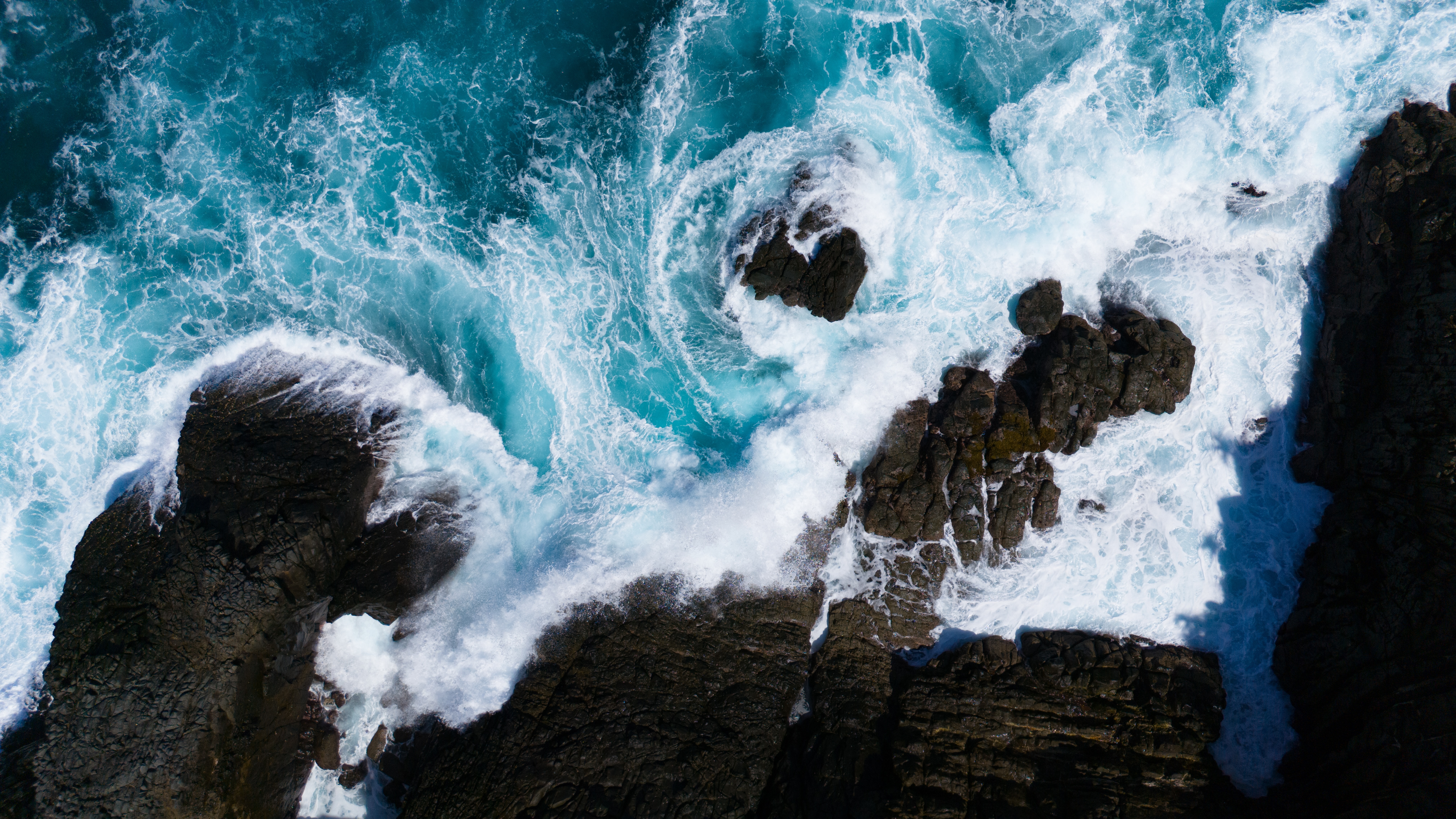 Aerial view of waves crashing against rock