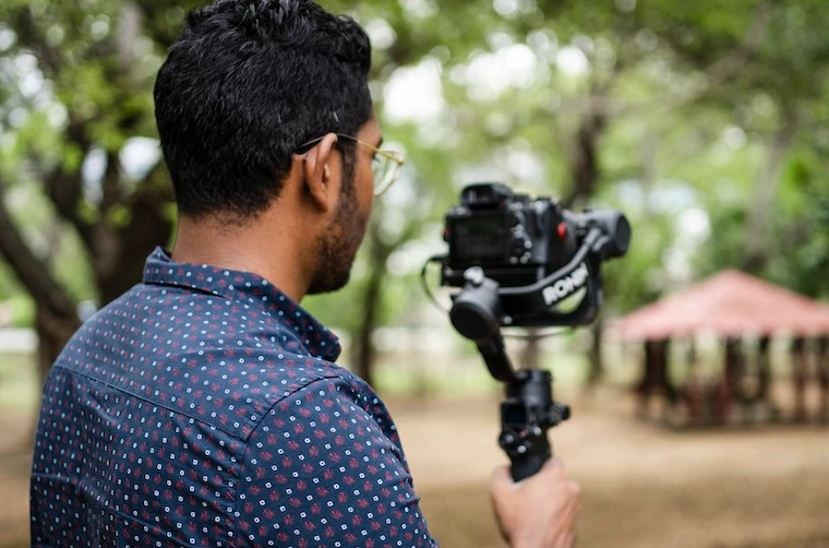 Photographe financé par l'Adie prenant une vidéo d'un événement 