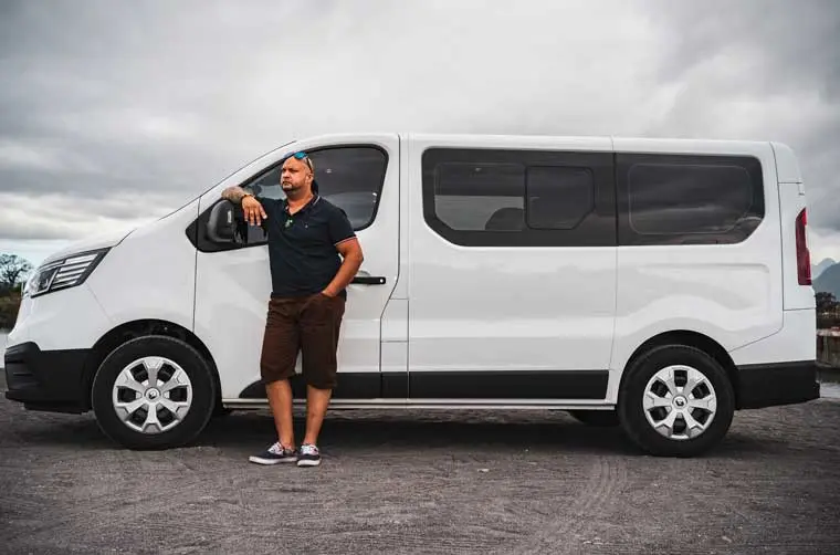 Chauffeur VTC financé par l'Adie s'appuyant sur son véhicule professionnel 