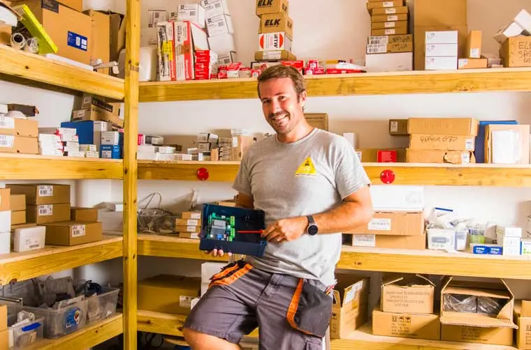 Stéphen, entrepreneur dans le bâtiment, pose dans son établi