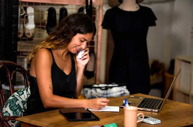 Entrepreneuse financée par l'Adie au téléphone avec l'un de ses clients