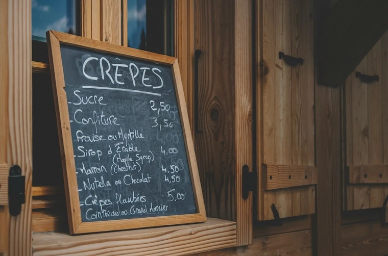 Ardoise indiquant les prix des crêpes sucrées d'un restaurateur financé par l'Adie