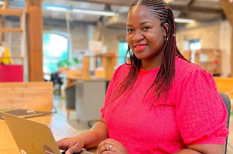 Entrepreneuse financée par l'Adie tapant sur son ordinateur
