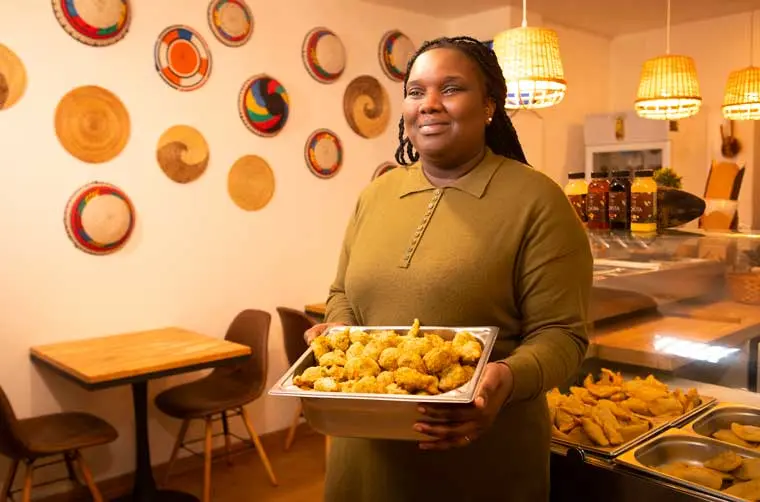 Entrepreneuse restauratrice financée par l'Adie tenant son plat