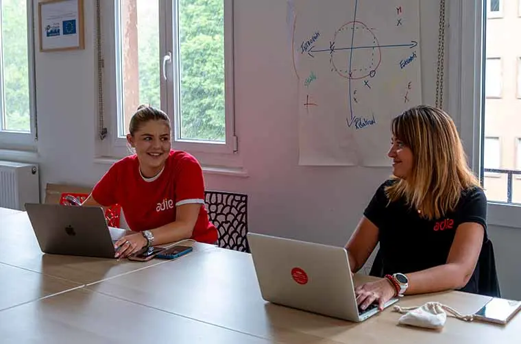 Jeune entrepreneuse financée par l'Adie discutant avec sa conseillère