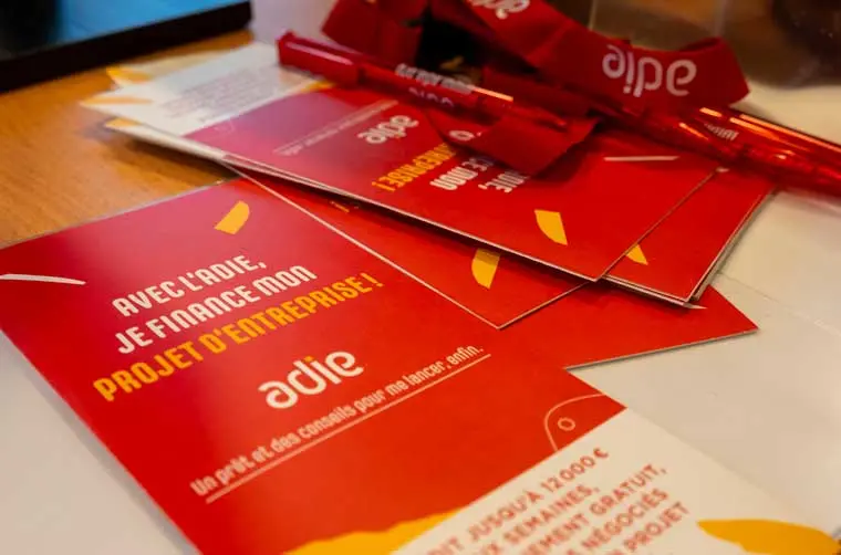 Flyers et goodies de l'Adie disposés sur un bureau