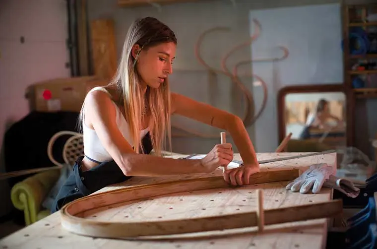 Entrepreneuse financée par l'Adie travaillant sur son projet artisanal en bois