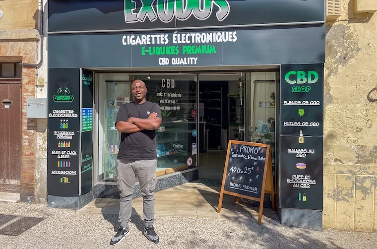 Entrepreneur financé par l'Adie devant sa boutique de cigarettes électroniques