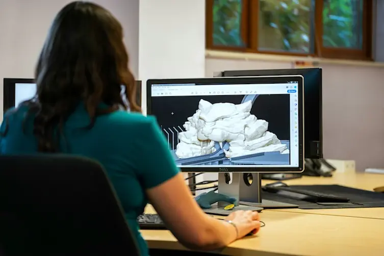 Entrepreneuse financée par l'Adie retravaillant une image sur son écran d'ordinateur