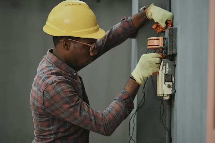 Électricien financé par l'Adie polissant un mur