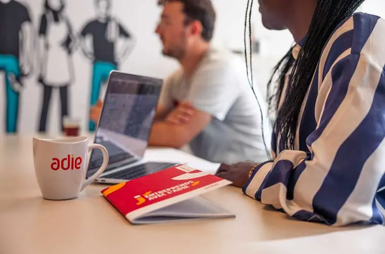 Entrepreneurs financés par l'Adie écoutant les recommandations d'un conseiller