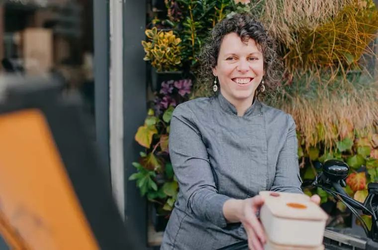Entrepreneuse financée par l'Adie tenant des emballages en bois pour son commerce