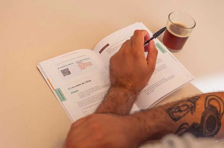 Entrepreneur financé par l'Adie s'informant sur les aides sociales de l'État à la création d'entreprise