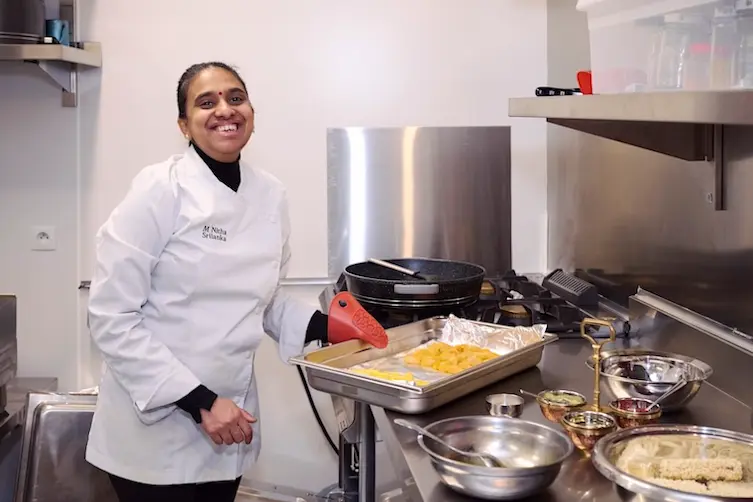 Restauratrice financée par l'Adie préparant un plat dans sa cuisine