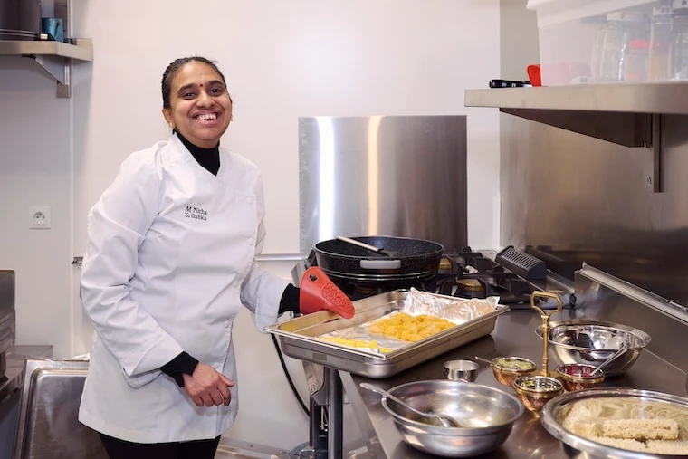 Restauratrice financée par l'Adie préparant un plat dans sa cuisine