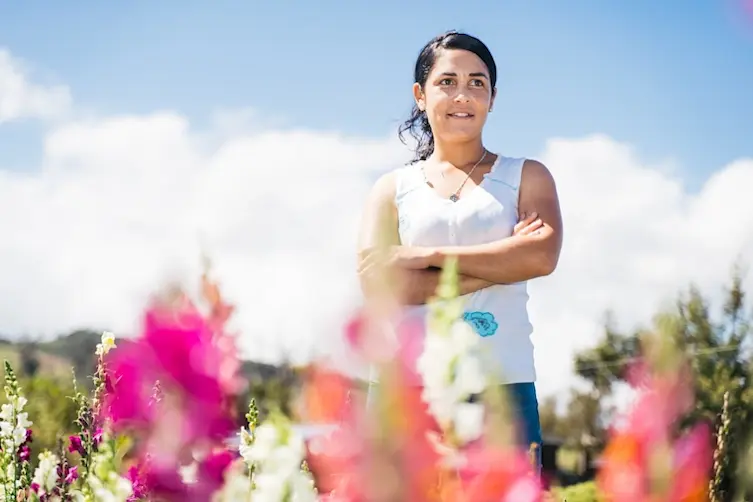 Entrepreneuse financée par l'Adie debout dans son champ de fleurs
