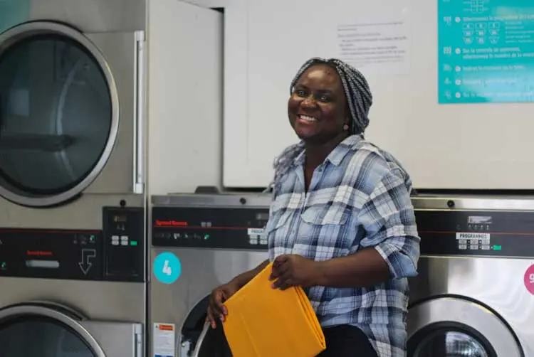 Entrepreneuse financée par l'Adie dans une laverie