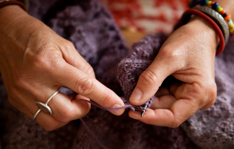 Les mains d'Emmanuelle qui tricote dans sa boutique "Ma P'tite Laine"