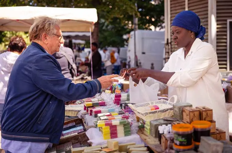 Entrepreneuse, propriétaire d'un commerce ambulant, financée par l'Adie servant un client