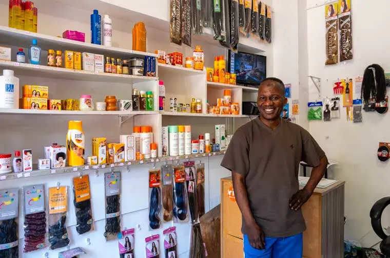 Entrepreneur financé par l'Adie debout dans son local commercial