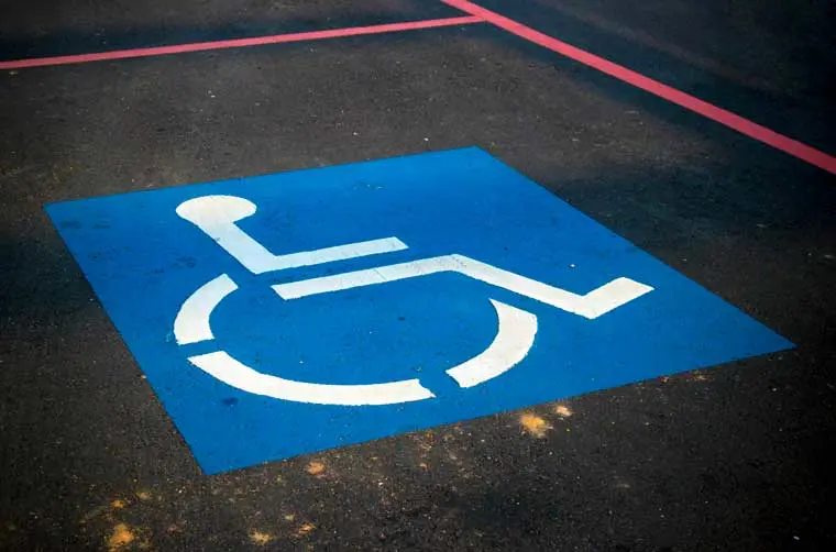 Peinture sur une place de parking indiquant qu'elle est réservée aux personnes en situation de handicap