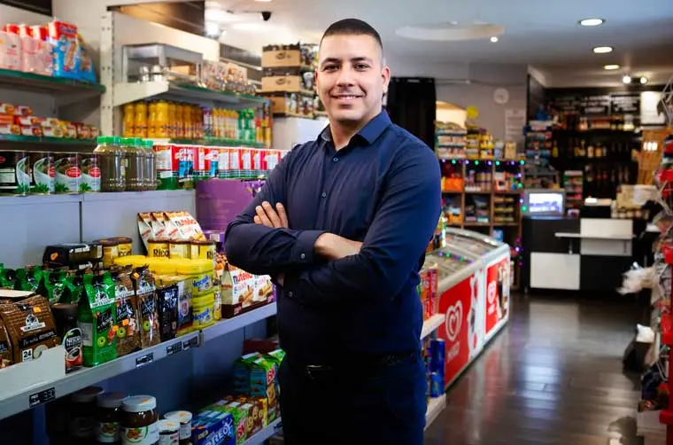 Entrepreneur financé par l'Adie dans son commerce de proximité