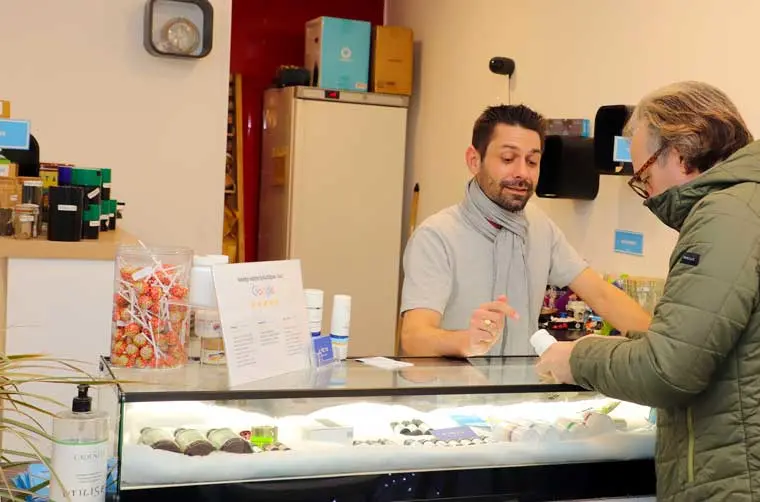 Entrepreneur financé par l'Adie conseillant un client à son comptoir