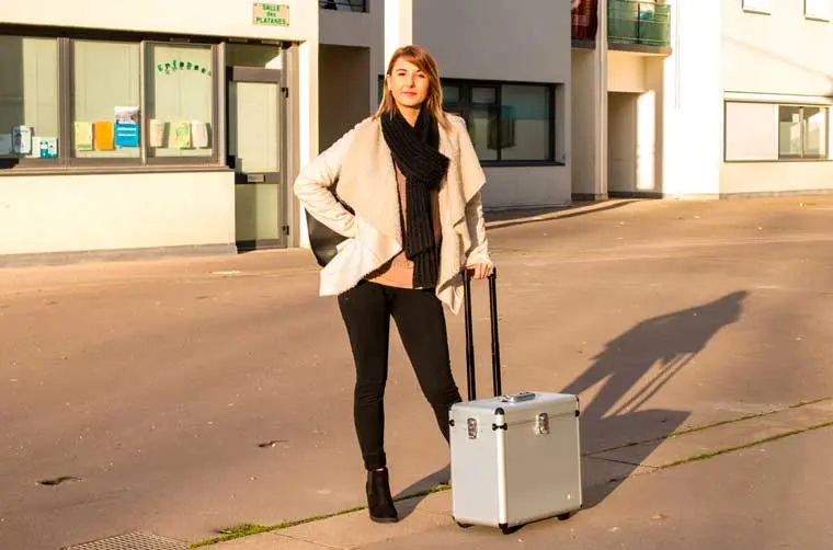 Coiffeuse à domicile financée par l'Adie transportant son matériel dans une valise